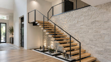 Modern open floating staircase with white oak treads, black steel support, and glass railing in a bright residential interior