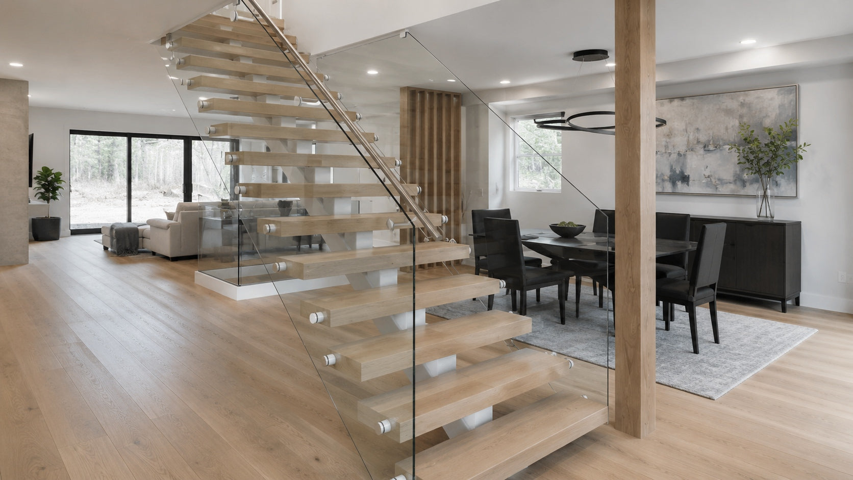 Modern open tread staircase with white oak treads, matte black steel support, and glass railing in a modern home