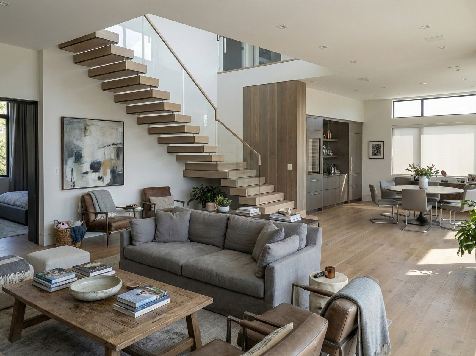 Custom floating stairs with wood treads, black steel stringer, and glass railing in a modern home.