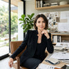 Chic editorial portrait of Elena S., a visionary Principal Interior Designer in California, smiling confidently in her bright, modern design studio showcasing intricate contemporary floating stairs by Elevated Stairs.