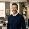 Professional portrait of James R., a successful New York homeowner, smiling warmly in his luxurious Brooklyn townhouse featured with modern floating stairs by Elevated Stairs.